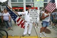 Opositores a la regularización de inmigrantes durante una protesta ayer en Postville, Iowa, donde las autoridades realizaron en mayo pasado una redada que terminó con 400 arrestos de indocumentados que trabajaban en la fábrica Agriprocessors