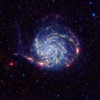 Recientes investigaciones revelaron que en la parte externa la galaxia Pinwheel, mejor conocida como Messier 101, carece de moléculas orgánicas, presentes en el resto de sus similares. Esta es una imagen captada por el telescopio Spitzer Space, de la NASA