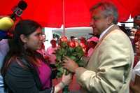 López Obrador recibe flores de una estudiante universitaria, luego de la consulta ciudadana