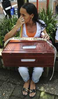 Edith Casarrubio sostiene los restos de su hermano, Oscar, asesinado por paramilitares hace años y cuyos restos fueron econtrados el pasado día 15 en Medellín, gracias a confesiones de integrantes desmovilizados de las AUC