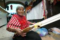 En el mercado de la Ciudadela, una indígena oaxaqueña labora en un telar