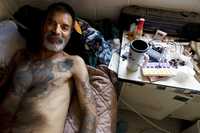Elías Rodríguez, quien fue deportado de Estados Unidos hace cuatro años por ser portador de VIH, reposa en su cama de un refugio en Tijuana