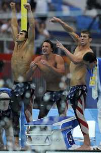 Michael Phelps (derecha) festeja con Ryan Lochte (centro) y Ricky Berens su victoria en 4x200 libres