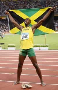 El jamaiquino Usain Bolt celebra su contundente triunfo en la prueba reina del atletismo, ante 90 mil espectadores en el Nido de Pájaro