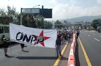 Integrantes de la Organizacion Nacional del Poder Popular permitieron por media hora el paso libre en la caseta México-Cuernavaca para protestar contra la privatización de Pemex