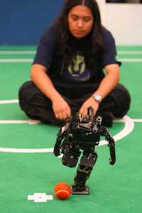 Uno de los robots participantes en el torneo de futbol, se prepara a ejecutar un disparo
