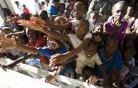 Niños haitianos piden agua a un grupo de la ONU que reparte ayuda en la devastada ciudad de Gonaives