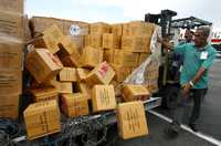 Trabajadores cubanos descargan en La Habana cajas que contienen sardinas y mantas enviadas por España para las víctimas del huracán Ike