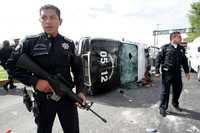Policías municipales de Ecatepec custodian las patrullas que fueron destrozadas ayer por un grupo de taxistas