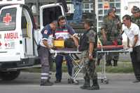 Elementos de rescate suben a una ambulancia a un herido tras uno de los enfrentamientos entre policías y presuntos sicarios en la carretera San Francisco del Rincón-León, en Guanajuato