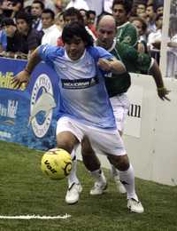 El mexicano Roberto Ruiz trata de quitarle el esférico al astro Maradona, durante el partido en Cancún