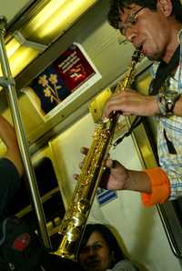 Un joven del colectivo Arte Bajo la Ciudad toca el saxofón en las estaciones de la Línea 3 del Metro