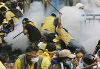 Manifestantes antigubernamentales son contenidos por la policía en Bangkok con gases lacrimógenes
