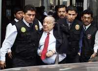 Alberto Quimper (centro), miembro del directorio de la paraestatal Petroperú, es detenido en Lima por agentes de las fuerzas de seguridad. Otro implicado, Rómulo León Alegría, continúa prófugo de la justicia
