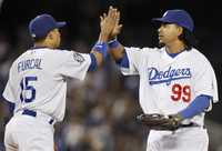 Manny Ramírez y Rafael Furcal, de los Dodgers, celebran la victoria de su equipo sobre los Filis