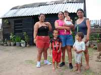 Marlén Martínez López, damnificada del huracán Ike, con sus vecinas, frente a su "facilidad temporal" o vivienda improvisada, en el barrio La Salomé de la ciudad de Camagüey, Cuba