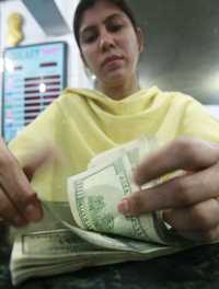 Cambista de Karachi, Pakistán, cuenta billetes de dólar, hace unos días