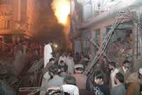 Residentes de Peshawar observan el lugar en el mercado donde explotó una bomba
