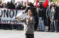 Un menor grita consignas contra la policía durante la protesta de ayer en Atenas, al crecer la tensión en el país tras la comparecencia ante un juez del policía acusado de matar a un joven durante una riña