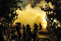 Manifestantes lanzan petardos en Atenas contra oficiales de la policía antimotines de Grecia