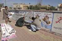 Simpatizantes del primer ministro iraquí Nuri Maliki colocan carteles de la próxima campaña electoral en Basora. Las elecciones provinciales en el país ocupado están programadas para el 31 de enero del año próximo