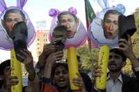 Manifestantes paquistaníes muestran sus zapatos y caricaturas del presidente de Estados Unidos, George W. Bush, ayer, durante una marcha en apoyo al periodista iraquí Muntazer Zaid, en la ciudad de Lahore. Los inconformes exigieron la liberación del reportero quien hace una semana lanzó su calzado contra el mandatario estadunidense
