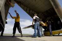 Voluntarios cargan un avión de las fuerzas armadas venezolanas con ayuda para los palestinos en Gaza