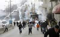 Palestinos que protestaban contra la ofensiva militar israelí son dispersados con bombas lacrimógenas por la policía en Ramallah, Cisjordania