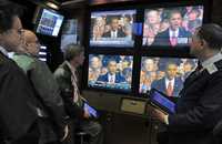 Corredores en el mercado de cambios de Nueva York siguieron ayer por televisión la ceremonia de la toma de posesión de Barack Obama como presidente de Estados Unidos