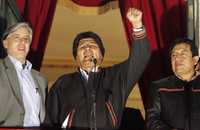 El presidente de Bolivia, Evo Morales, acompañado del vicepresidente Álvaro García Linera (a la izquierda), y del ministro del Exterior, David Choquehuanca (a la derecha), festejan desde un balcón del palacio Murillo, en La Paz, la aprobación en un referendo a la nueva Constitución del país